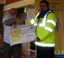 Kevin Lee accepting the cheque for £500 from Lion President Brian Richards